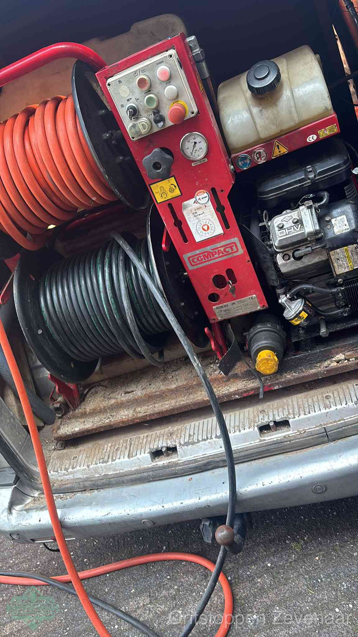 Een rood hogedruk-rioolreinigingstoestel in de laadbak van de bedrijfsbus, apparatuur voor een hardnekkige afvoerverstopping in Zevenaar