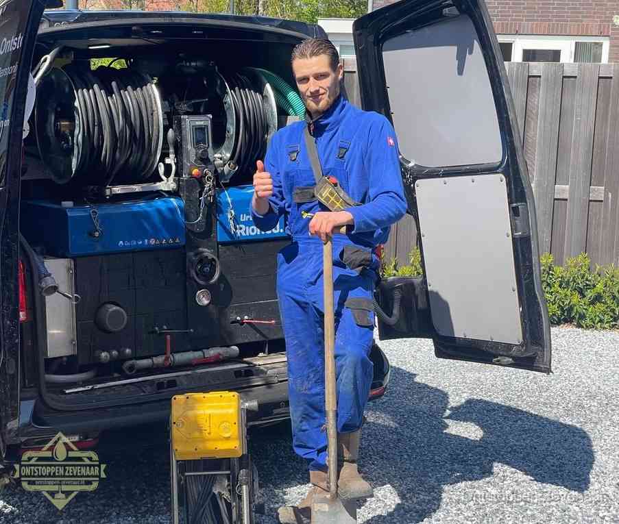 Een monteur bij de werkbus met grote hogedruk-slanghaspels, apparatuur voor hardnekkige afvoerverstoppingen in Zevenaar