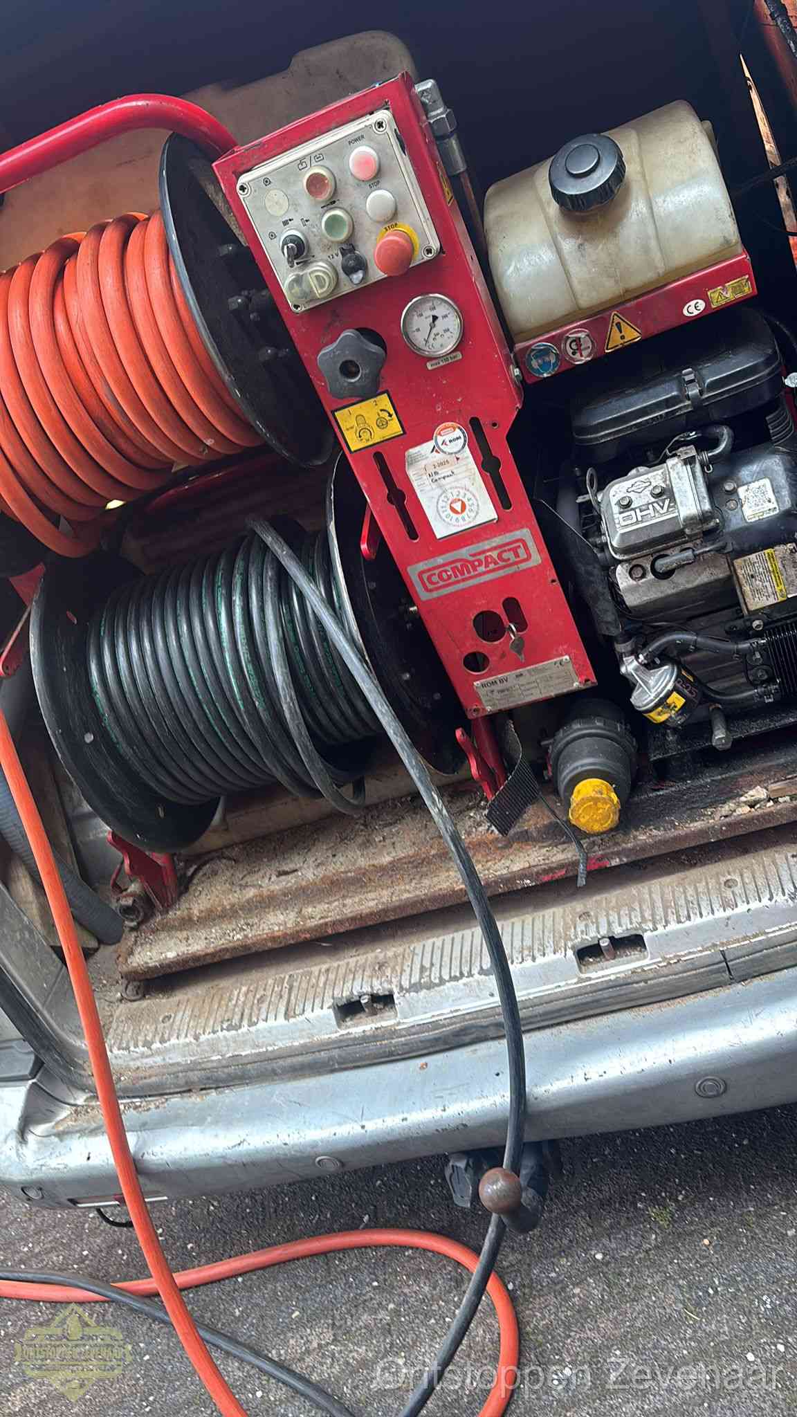 Een rood hogedruk-rioolreinigingstoestel met slangen in de laadbak van de bedrijfsbus, apparatuur voor een hardnekkige wc-verstopping in Zevenaar