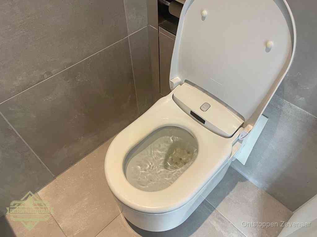 Een toiletpot vol troebel water met drijvend papier en restanten, de meest voorkomende oorzaak van een verstopte wc in Zevenaar