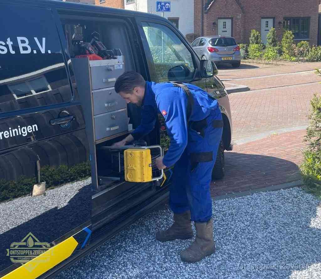 Een monteur pakt apparatuur uit de bedrijfsbus voor service aan huis, het moment om een professional in te schakelen voor een verstopte wc in Zevenaar