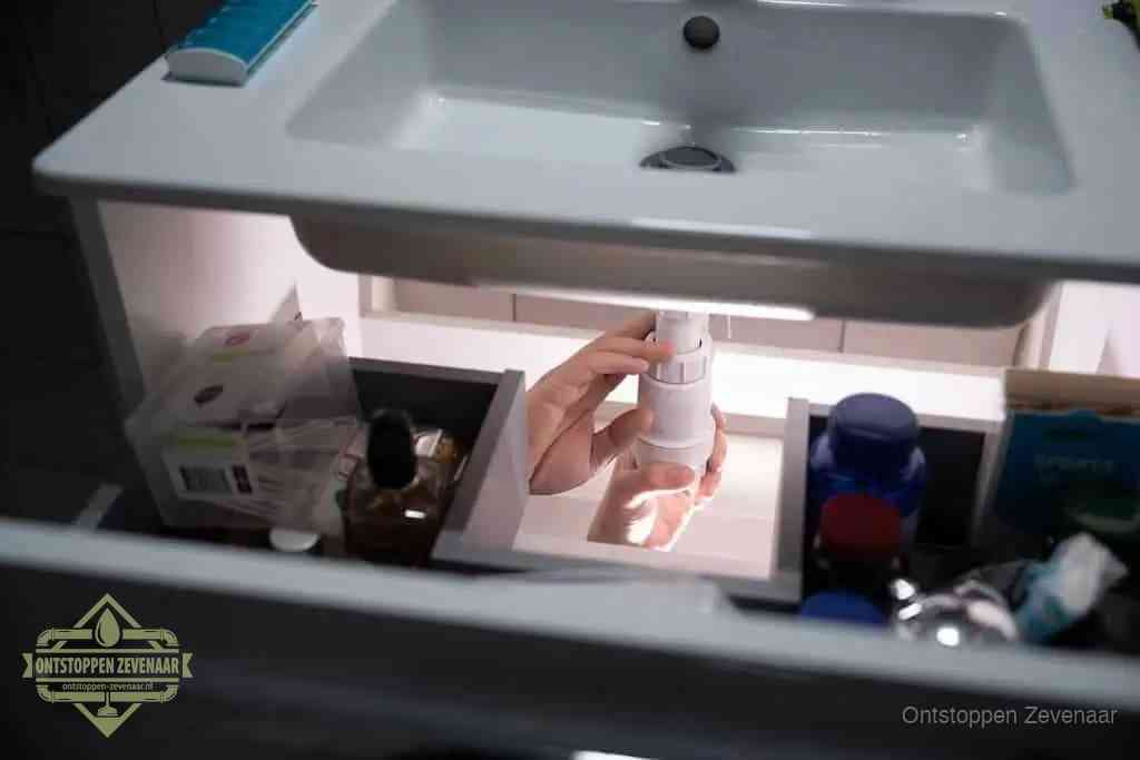 Een pompfles met zeep boven een wastafel in de toiletruimte, de warm water en afwasmiddel-methode om de wc te ontstoppen in Zevenaar